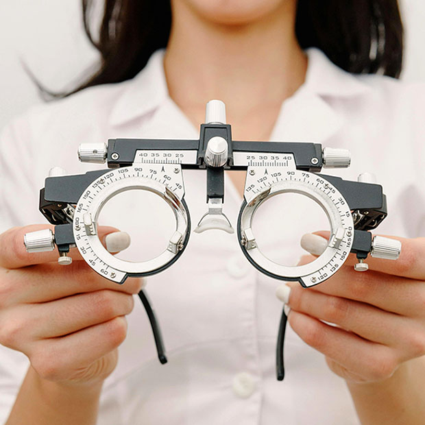 An optometrist conducting an eye exam using a phoropter